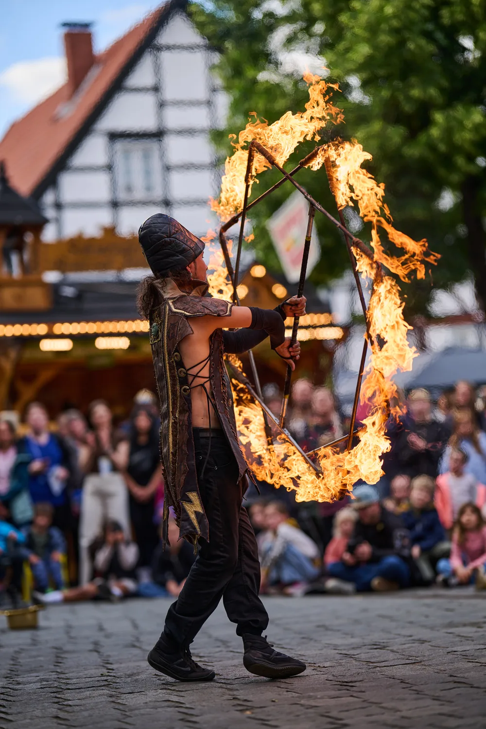 Dario performing with a burning hoop in a street show