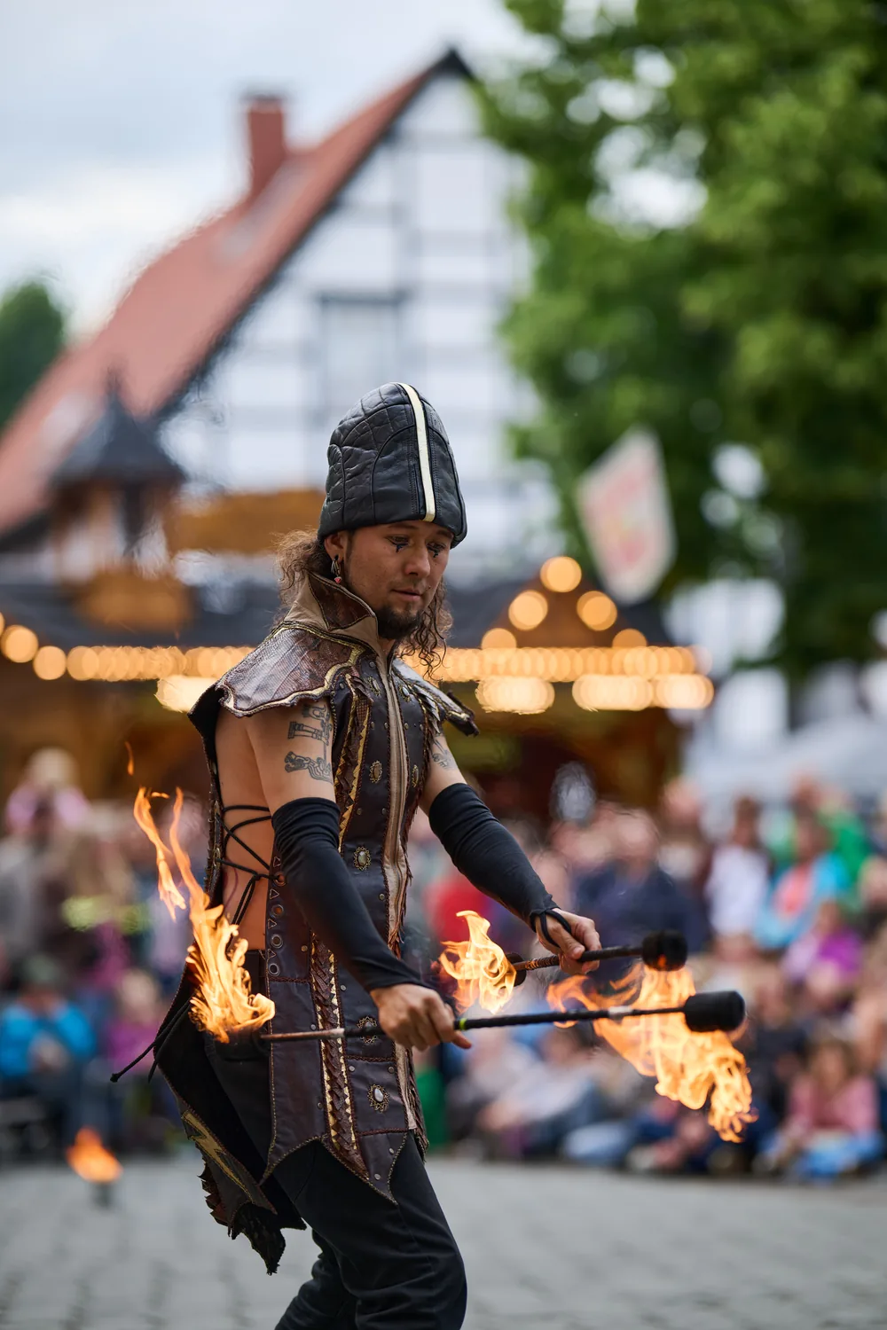 Dario spinning a fire staff in a town square