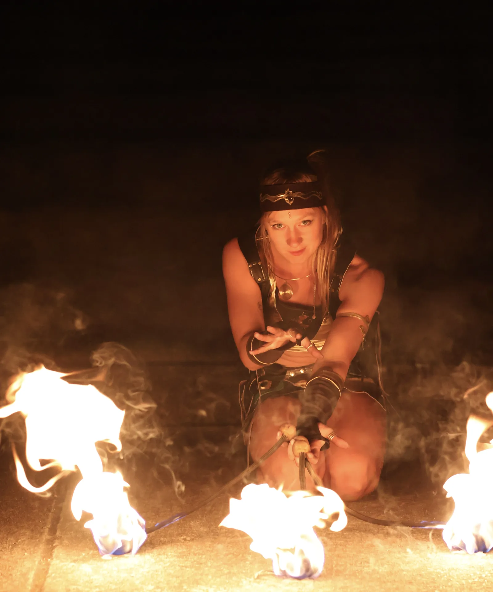 Performer crouching between flames