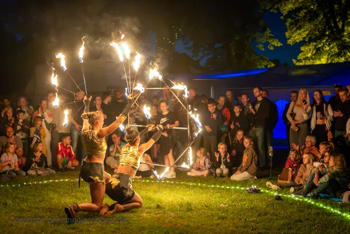 Festival crowd watching a burning geometric structure