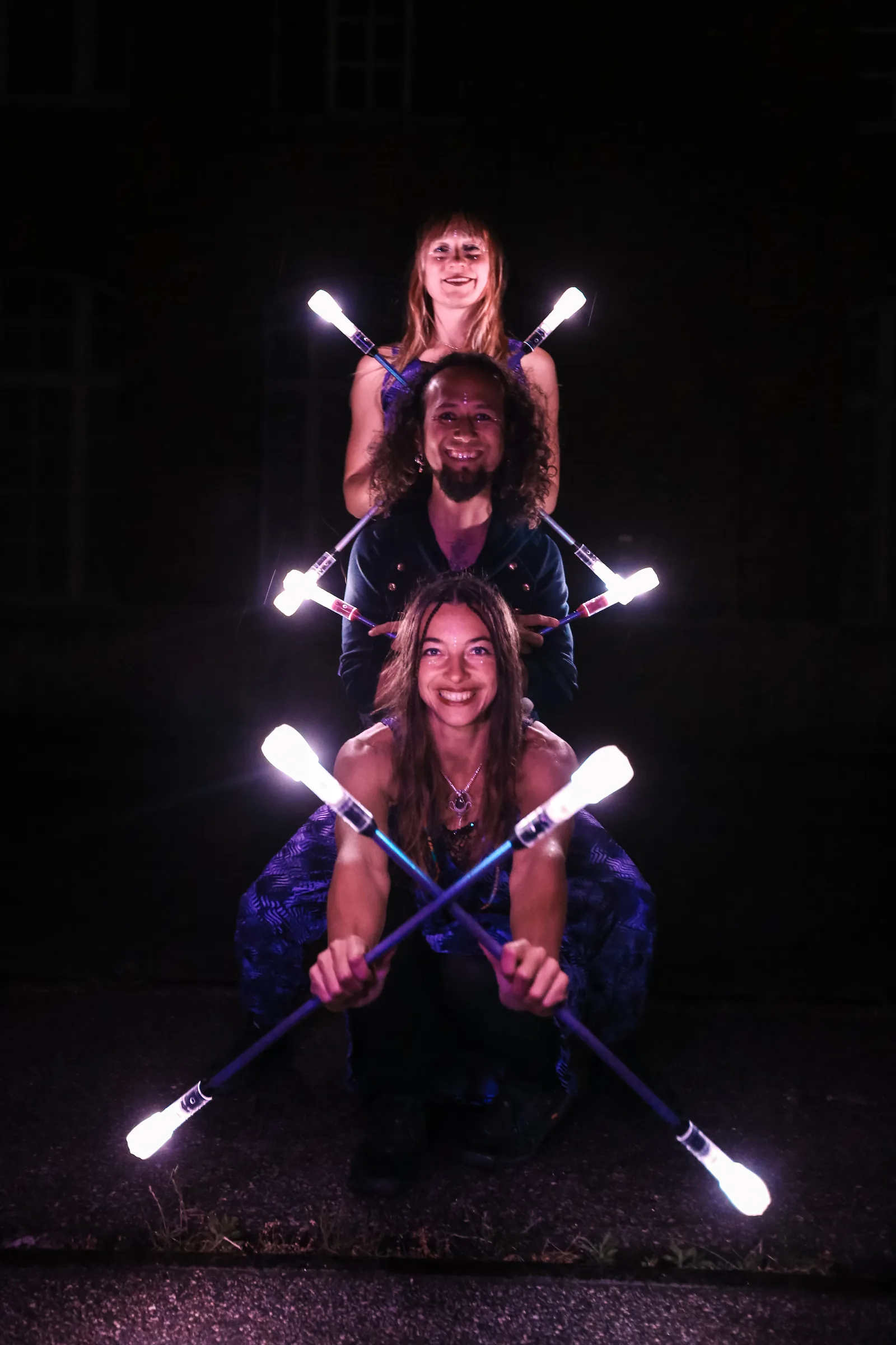 Three smiling performers with LED props