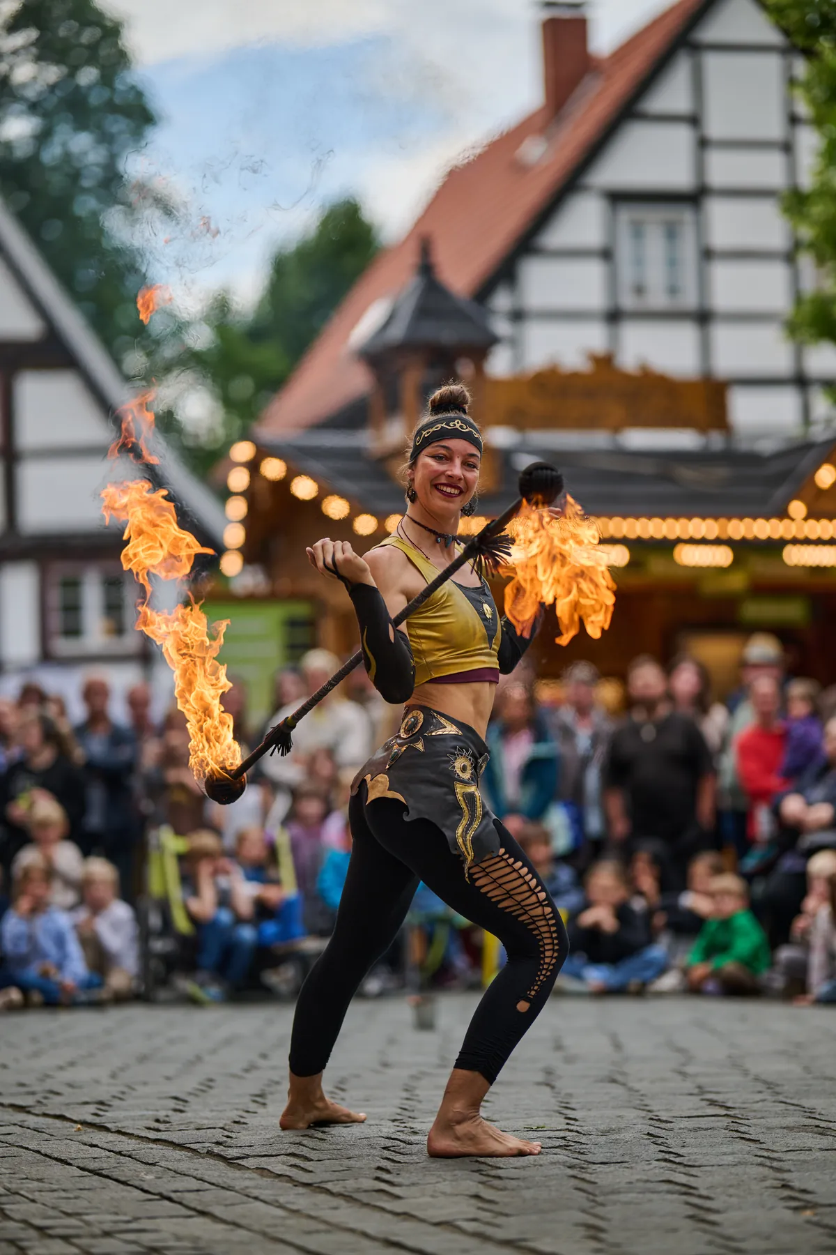 Mascha with fire fans in front of a street audience