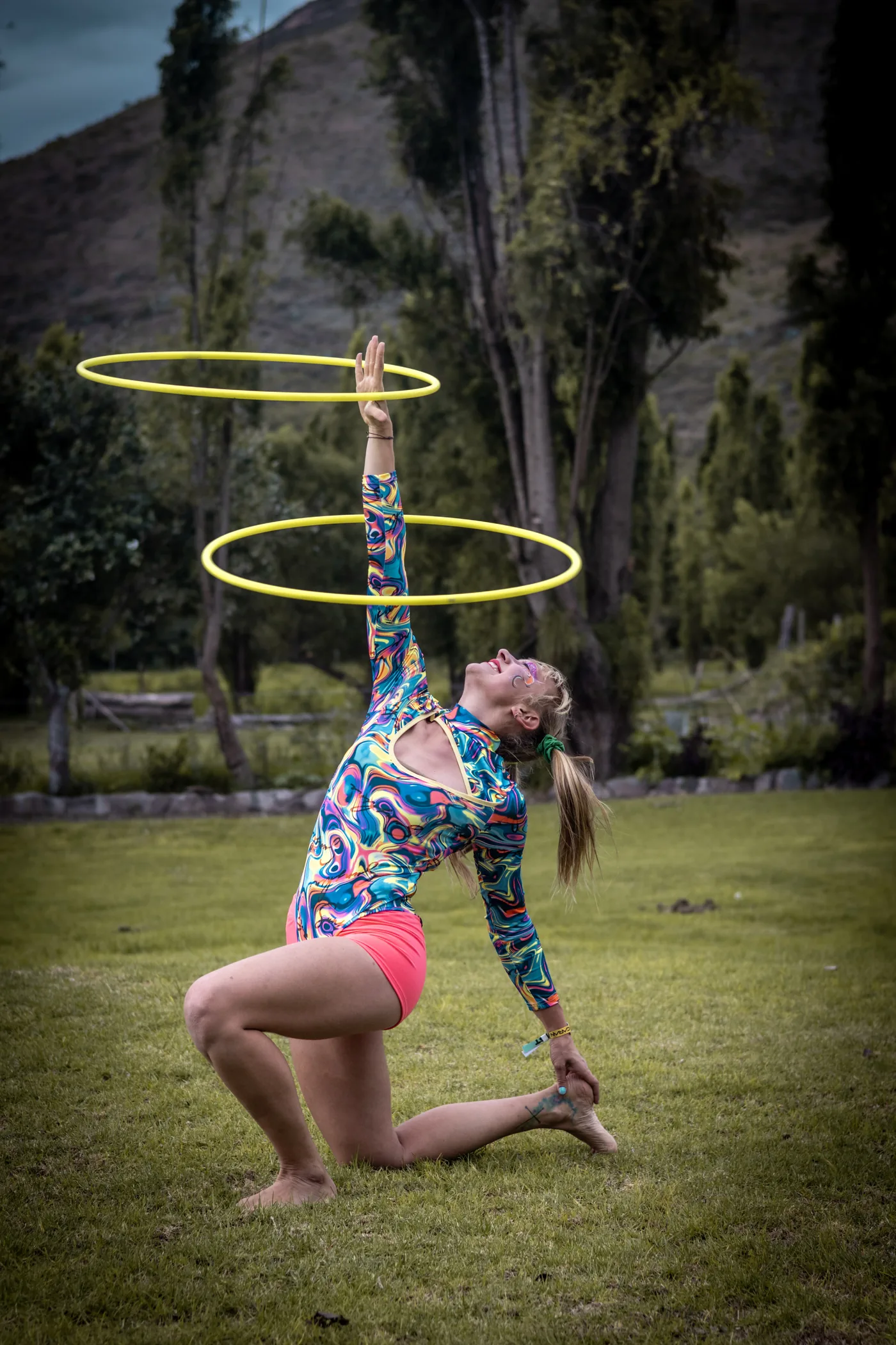 Kalayo artist spinning two hula hoops in a park in daylight